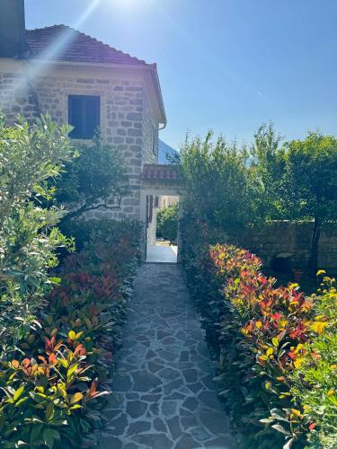 a stone pathway leading to a house with flowers at Apartments Radonicic in Kotor