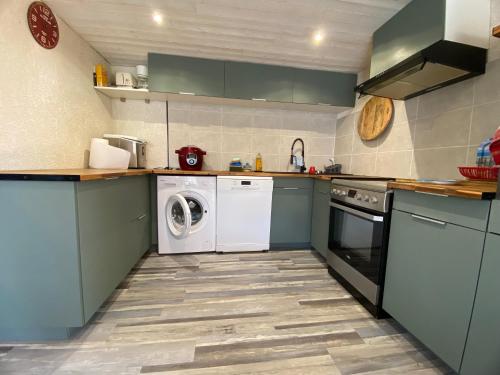 - une cuisine avec des placards bleus et un lave-linge/sèche-linge dans l'établissement Maison à 350 m de la plage animaux bienvenus, à Sainte-Marie-la-Mer