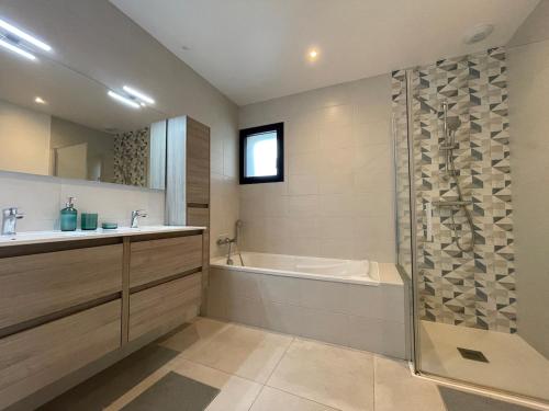 une salle de bain avec une baignoire, un lavabo et une douche dans l'établissement Maison récente bord de mer Binic, à Binic
