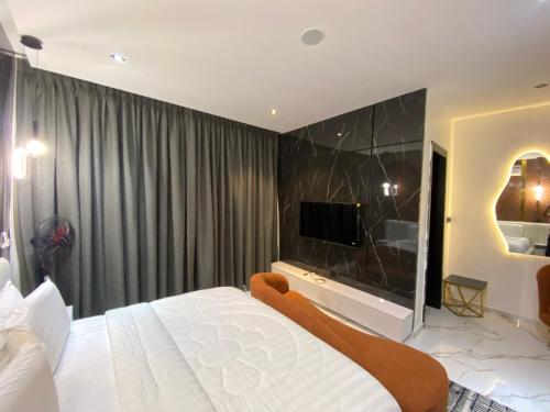 a bedroom with a large white bed and a flat screen tv at Jasmine in Badore