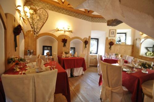 a restaurant with two tables with red table cloths at Hotel Al Forte in Arabba
