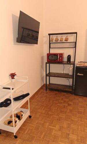 a room with a wooden floor and a shelf with shoes at Friendly Home 3 trilocale in Sedriano