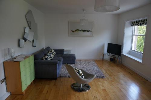 a living room with a couch and a chair at Chaucer View, Chaucer House Apts in Keswick