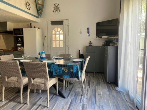 une cuisine avec une table avec des chaises et un réfrigérateur dans l'établissement Maison à 350 m de la plage animaux bienvenus, à Sainte-Marie-la-Mer