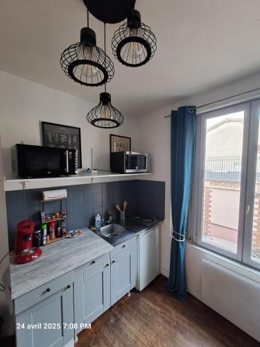 une cuisine avec un comptoir, un évier et une fenêtre dans l'établissement Le petit nid au coeur de Troyes, à Troyes