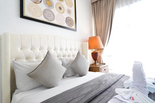 a bedroom with a white bed with pillows at 2BR Lucky Tower Residence Jakarta Old Town Top Floor Condo in Jakarta