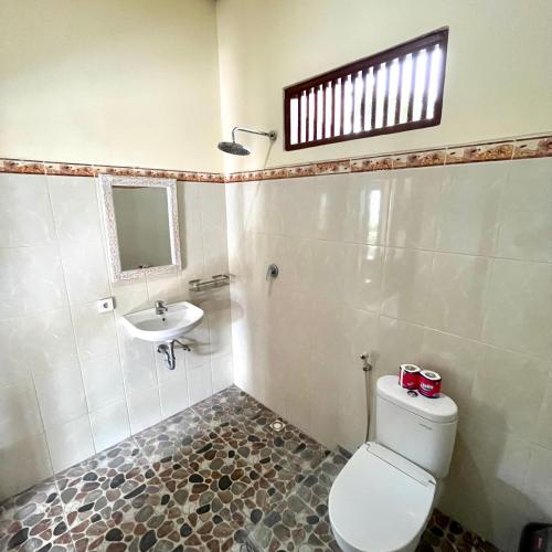 a bathroom with a toilet and a sink at Dodit House in Ubud