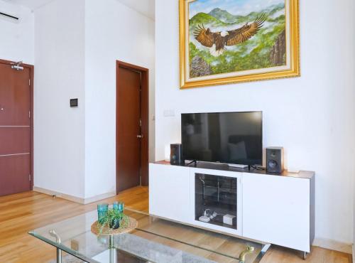 a living room with a tv and a glass table at 2BR Lucky Tower Residence Jakarta Old Town Top Floor Condo in Jakarta