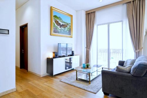 a living room with a couch and a tv at 2BR Lucky Tower Residence Jakarta Old Town Top Floor Condo in Jakarta