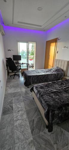 a room with two beds and a desk and a table at Luxury Apartment Seaside in Sousse Tourist zone - Internet WIFI in Sousse