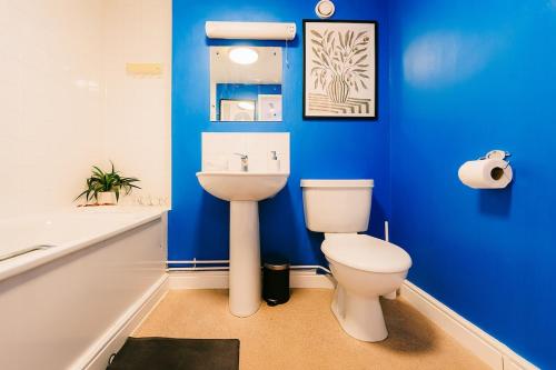 ein blaues Badezimmer mit Toilette und Waschbecken in der Unterkunft Trendy Accommodation in Arsenal in London