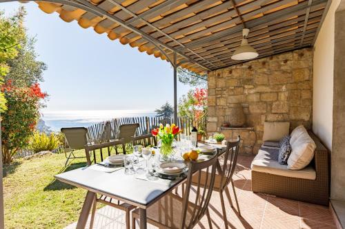 un patio avec une table, des chaises et un canapé dans l'établissement LA PERLE Bellavista, à Menton