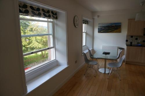 a room with a table and two chairs and a window at Chaucer View, Chaucer House Apts in Keswick