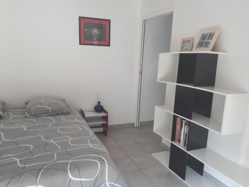 une chambre avec un lit et une étagère dans l'établissement Ty Chaméléon, à Trégastel