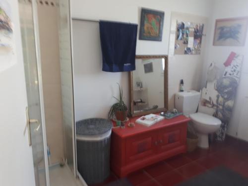 La salle de bains est pourvue d'un lavabo rouge et de toilettes. dans l'établissement Ty Chaméléon, à Trégastel