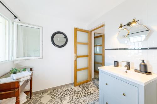 une salle de bain avec un lavabo et un miroir dans l'établissement LA PERLE Bellavista, à Menton