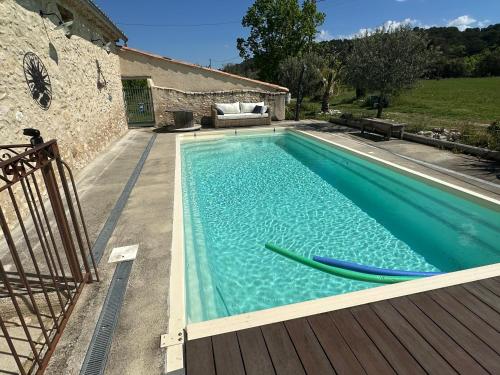 une piscine avec deux planches de surf sur une terrasse en bois dans l'établissement SouthCorner - Le Coin du Sud, à Malaucène