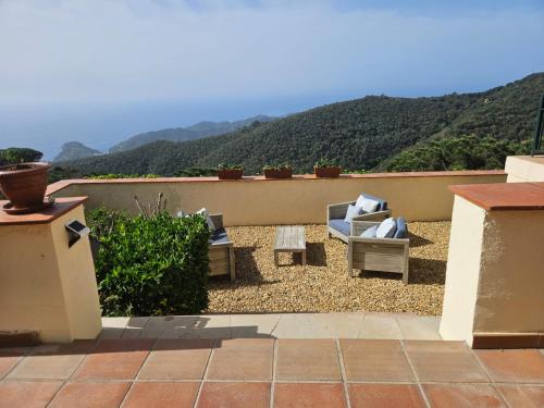 a patio with two chairs and a view of mountains at La Roqueta Hotel in Tossa de Mar
