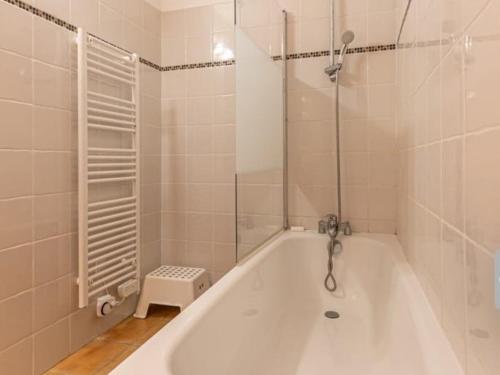 La salle de bains est pourvue d'une baignoire blanche et d'une douche. dans l'établissement Appartement confortable 6 pers avec terrasse et internet à Aussois - FR-1-508B-5, à Aussois
