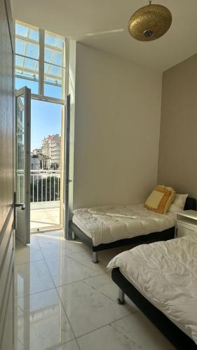 une chambre avec deux lits et un balcon dans l'établissement Villa carré des musiciens, à Cannes