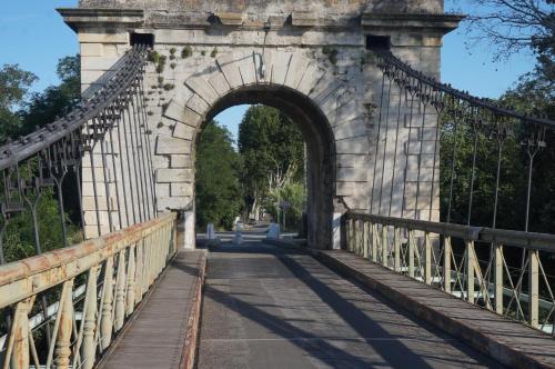 un pont en arc sur une route dans l'établissement Charmante maison de village avec patio FOURQUES 10 minutes à pied d'Arles, à Fourques