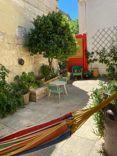 d'une terrasse avec une table, des chaises et un arbre. dans l'établissement Charmante maison de village avec patio FOURQUES 10 minutes à pied d'Arles, à Fourques