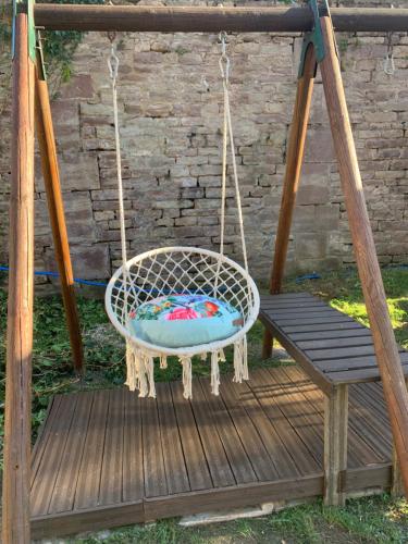 a swinging chair and a bench on a wooden deck at Hôtel Le 43 in Luxeuil-les-Bains