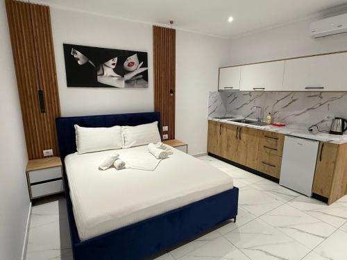 a bedroom with a large bed and a kitchen at Full Moon Apartments in Ksamil