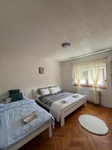 two beds in a room with two windows at Kuća za odmor Ana in Oklaji