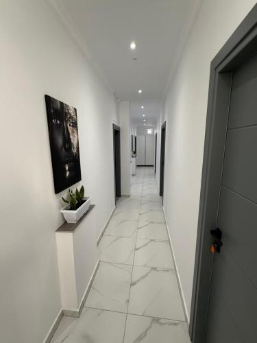 a hallway with white walls and a tile floor at Full Moon Apartments in Ksamil