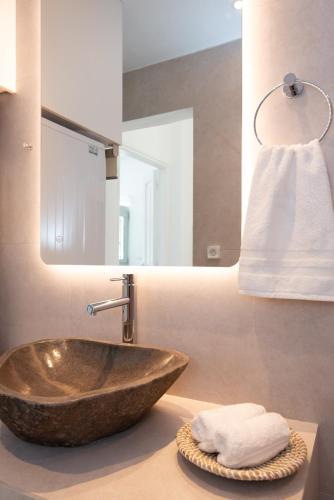 a bathroom with a bowl sink and a mirror at BLUE VILLA Sifnos in Kamarai