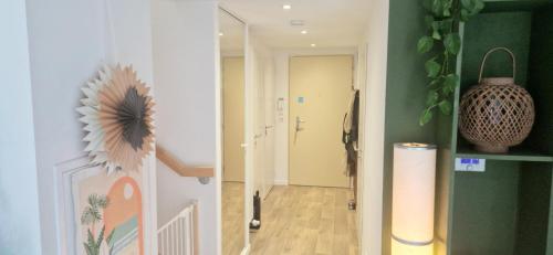 Cette chambre dispose d'un couloir avec un miroir et une porte. dans l'établissement Maison cosy proche du centre-ville, à Vannes