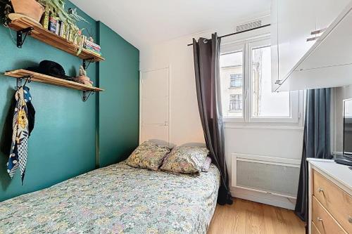 une chambre avec un lit et un mur bleu dans l'établissement Cosy duplex close to Notre Dame, à Paris