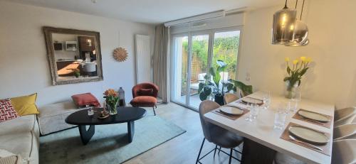 un salon avec un canapé et une table avec des chaises dans l'établissement Maison cosy proche du centre-ville, à Vannes