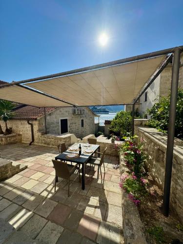 a patio with a table and chairs under a canopy at Apartments Radonicic in Kotor