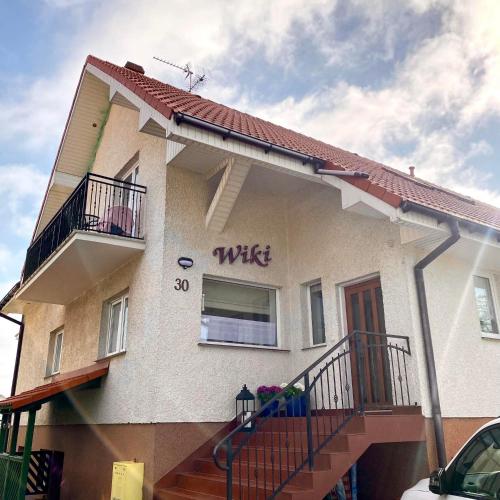 a house with a sign on the side of it at Dom Gościnny Wiki in Rewal