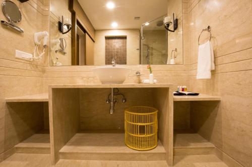 a bathroom with a sink and a mirror at Kiscol Grands Hotel in Coimbatore