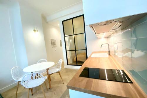 une cuisine avec un comptoir, une table et des chaises dans l'établissement Bright apartment near the beach, à Antibes