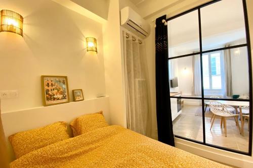 une chambre avec un lit et une grande fenêtre dans l'établissement Bright apartment near the beach, à Antibes