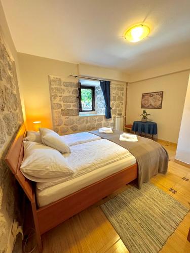 a bedroom with a large bed and a stone wall at Apartments Radonicic in Kotor