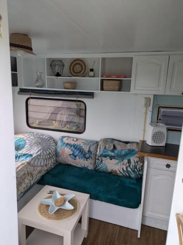a small caravan with a couch and a table at Gerestylde vintage caravan "Zee" met luxe badkamer bij "de Kapitein" in 't Horntje
