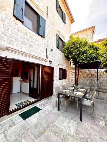 a patio with a table and chairs in front of a building at Apartments Radonicic in Kotor