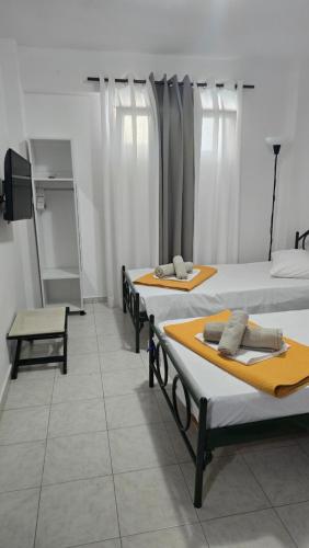 a room with three beds and a tv in it at VILLA CARIATIS in Nea Kalikratia