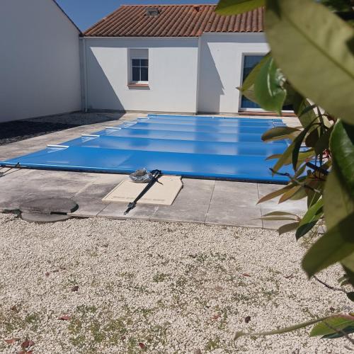 une piscine bleue devant une maison dans l'établissement MAISON individuelle près des PLAGES, à Saint-Hilaire-de-Riez