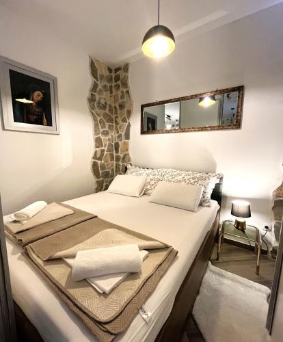 a bedroom with a large white bed with a mirror at Madona di Sinj in Sinj