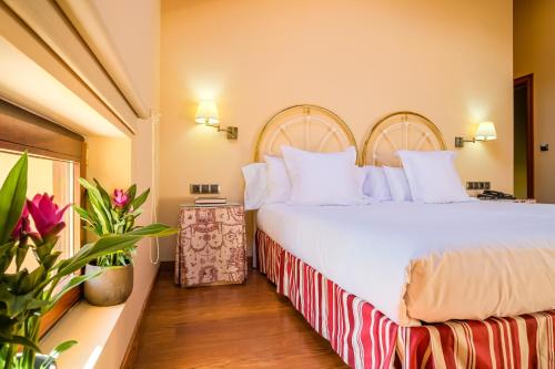 a bedroom with a large bed with white pillows at Indiana Boutique Hotel in Llanes