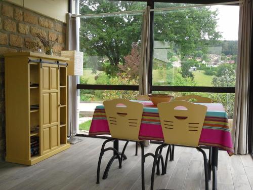 une salle à manger avec une table et des chaises et une fenêtre dans l'établissement Le Gros Chene, à Sarlat-la-Canéda