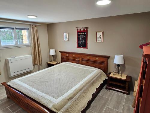 une chambre avec un grand lit et deux lampes dans l'établissement Le Gros Chene, à Sarlat-la-Canéda