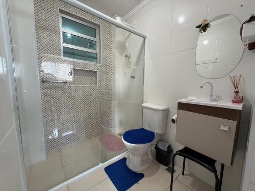 a bathroom with a shower and a toilet and a sink at Kitão Frente Mar Na Tupi! in Samaritá