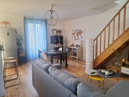 un salon avec un canapé et une table dans l'établissement Appartement cosy duplex Vichy, à Vichy